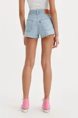 Short de jean tiro medio con diseño de cinco bolsillos, cierre de botones y ruedo desflecado.