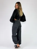 Pantalon de denim azul con diseño de rayas verticales blancas, de corte holgado y estilo relajado.