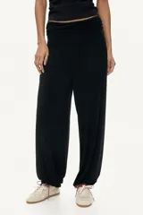 Pantalón de corte holgado en punto de viscosa, de color negro, con cintura elástica ancha fruncida y piernas estilo globo con puños elásticos en los tobillos.