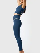 Calza deportiva azul con cintura cruzada en forma de V y detalle bicolor en tono beige debajo de la pretina.