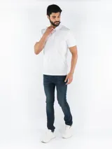 Chomba blanca de algodón y poliéster, de manga corta, con cuello polo y tapeta de dos botones. Tiene corte regular y logo de Calvin Klein bordado en el pecho.