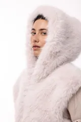 Campera de invierno con frente de piel sintética y capucha integrada, combinada con mangas acolchadas de estilo puffer en color marrón oscuro.