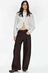 Camisa de corte oversize con estampado de rayas verticales, cuello solapa, cierre frontal con botones y mangas largas con puños abotonados.