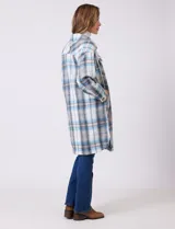 Sobrecamisa larga de tejido soft con estampado de cuadros en tonos celestes, beige y blanco. Presenta cuello con solapa, cierre frontal con botones, bolsillos aplicados en el pecho y mangas largas con puños abotonados.