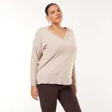 Sweater de punto fino en color beige, con escote en V, mangas largas y diseño holgado con aberturas laterales en el ruedo.