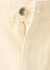 Jeans de tiro alto color beige con diseño recto, cinco bolsillos y detalles bordados calados en la parte inferior de las piernas.