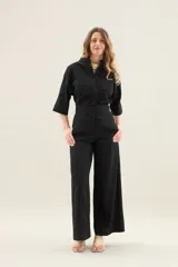 Pantalón largo negro de tiro alto, con costuras centrales en las piernas y diseño de pernera ancha.