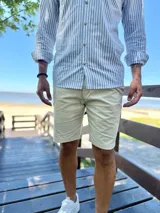 Bermuda de gabardina color beige, con bolsillos laterales y traseros, de corte recto y clásico.