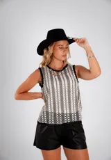 Musculosa de tejido calado color blanco y negro, con cuello redondo y terminaciones en crochet.