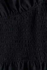 Top negro de mezcla de viscosa, con escote en V pronunciado, mangas cortas de tipo japonesa y cuerpo fruncido bajo el busto con detalle de volado en el bajo.