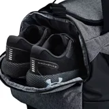 Bolso Under Armour unisex, modelo Undeniable 5.0, color gris con detalles en negro y amarillo. Cuenta con tecnología UA Storm repelente al agua, paneles inferiores y laterales resistentes, bolsillo ventilado para ropa o calzado, bolsillos interiores para organización, bolsillo frontal con cierre, doble bolsillo para botella de agua y correa ajustable para el hombro.