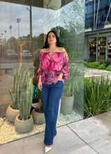 Blusa con hombros descubiertos, estampado floral en tonos rosados y mangas largas abullonadas.