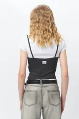 Top negro con estampado de cuadros blancos, escote en V y mangas largas.