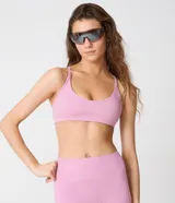 Top deportivo Get Over confeccionado en microfibra rosada, con diseño de cuello redondo, tirantes medianos y espalda nadadora. Cuenta con copas incorporadas y alta elasticidad.