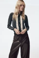Chaqueta de punto gris oscuro con cuello solapa y manga larga. Presenta un diseño frontal con detalle de puntilla en color crema a contraste y cierre con botones.