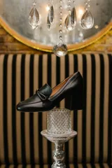 Zapato de cuero rojo con aplique decorativo en el empeine y tacón cuadrado.