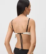 Top de bikini Bossa Nossa con diseño color block en negro y blanco, confeccionado en microfibra con textura plisada. Presenta copa estructurada con aro, breteles finos regulables y un detalle de botón decorativo en el centro.