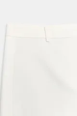 Pantalón balloon de tiro medio en color blanco, confeccionado en algodón, con trabillas en la cintura y bolsillos laterales ocultos.