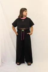 Pantalón de jogging de corte ancho y tiro alto, con cintura elástica, cordones ajustables y un aplique decorativo de acrílico en el frente. Cuenta con bolsillos laterales.