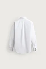 Camisa regular fit de algodón con diseño de rayas finas celestes y blancas. Cuenta con cuello abotonado, manga larga con puños abotonados y cierre frontal de botones.