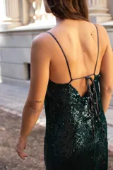 Vestido midi de corte recto confeccionado en lentejuelas color verde oscuro, con escote en V y breteles finos.