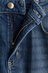 Jean wide leg de tiro alto en denim de algodón con ligero stretch, cinco bolsillos, lavado azul con efecto deslavado y terminación desmechada en el bajo.