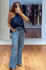 Top color beige claro con escote halter y tres volados. Incluye una rosa de tela removible en el cuello.