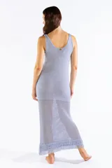 Vestido largo de punto abierto con brillo de lúrex y flecos en el ruedo, de corte recto, sin mangas y escote en V.