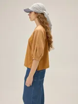 Gorro pañuelo color beige, con visera incorporada y diseño liviano con detalles deshilachados en el borde de la visera.