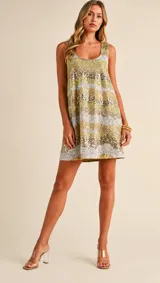 Vestido mini sin mangas de corte relajado, completamente bordado con lentejuelas en tonos dorados, plateados y destellos verdosos formando franjas horizontales.