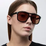 Lentes de sol de aviador con montura negra oversized y doble puente. Lentes marrones de nylon con protección UV400.