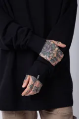 Buzo de corte oversize confeccionado en tela friza, con cuello redondo y puños acanalados. Presenta un diseño minimalista con un pequeño bordado en el pecho y un diseño estampado en la espalda.