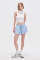 Short de poliéster color negro, de calce holgado y tiro alto, con cintura elástica y cordón ajustable.