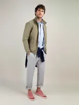 Cazadora estilo Harrington color verde militar, con cuello alto, cierre frontal con cremallera, bolsillos laterales con solapa y puños y dobladillo acanalados.