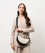 Cartera tipo shoulder de diseño curvo y estructura mediana, confeccionada en tejido texturizado con detalles en material sintético negro. Cuenta con cierre superior y correa ajustable y desmontable.