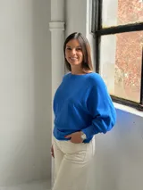 Sweater de punto color azul vibrante, con diseño de textura acanalada vertical en el frente, cuello redondo y mangas murciélago con puños ajustados.