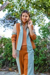 Chaqueta de corte recto con diseño multicolor en bloques de color naranja, lila y amarillo. Presenta cuello mao, mangas largas con puños vueltos y bolsillos laterales.