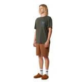 Remera de algodón color verde oscuro con cuello redondo y manga corta. Presenta un pequeño estampado gráfico en el pecho que muestra un jarrón con flores en color azul.