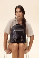Mochila de cuero vacuno color marrón, con diseño estructurado y combinación de textura croco en el bolsillo frontal. Cuenta con un compartimento principal con cierre, un bolsillo frontal con cierre metálico y hebillas decorativas, y correas regulables.