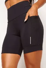 Short tipo biker de tiro alto, diseñado para running y entrenamiento. Confeccionado en tejido técnico de alta performance con bolsillos laterales funcionales y bolsillo interno en la cintura. Presenta detalles reflectivos y costuras estratégicas para mayor libertad de movimiento.