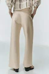 Pantalón de tiro alto con pinzas delanteras, bolsillos frontales y pernera recta. Cuenta con cierre frontal de cremallera, botón interior y gancho.