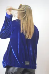 Campera azul de terciopelo con cierre frontal y cuello polo.