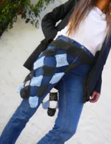 Vestido midi tejido a mano en crochet color celeste, con diseño de falda asimétrica y detalle de faja ajustable en contraste color gris oscuro con patrón de damero.