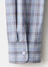Camisa oversize de algodón con estampado a cuadros, cuello camisero, cierre frontal de botones y mangas largas.