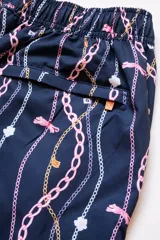 Short de baño azul marino con estampado de cadenas doradas, charms y libélulas en rosa.