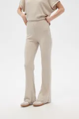 Pantalón acampanado de poliéster y lurex, color beige, de tiro alto y corte holgado.
