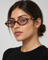 Lentes de sol Miu Miu modelo 04z, con montura ovalada de acetato en tono carey, lentes ultraplanas de color rosado claro y el logo de la marca en relieve dorado en las patillas.
