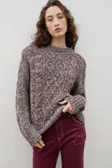 Buzo de lana con diseño de trenzas y ochos, de cuello redondo y calce holgado.