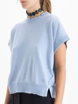 Chaleco de tejido de punto en color celeste, con cuello redondo y mangas cortas con terminación en rib. Presenta un diseño holgado con aberturas laterales en el ruedo y un pequeño bordado decorativo en la parte inferior.