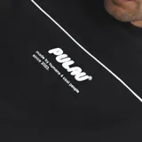 Buzo crewneck de corte oversize, con diseño bicolor en negro y gris, estampado con relieve en el frente y mangas largas.